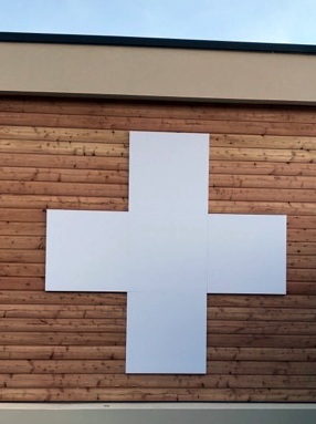 Habillage de façade réalisé en PVC 19 mm laqué blanc en forme de croix à proximité de Lyon par SES à Pharmacie de la Boisse